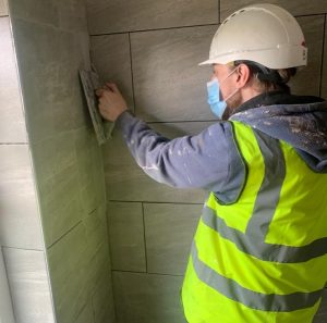 participant tiling the bathroom