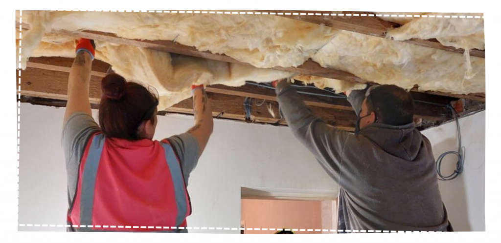 two people installing ceiling insulation